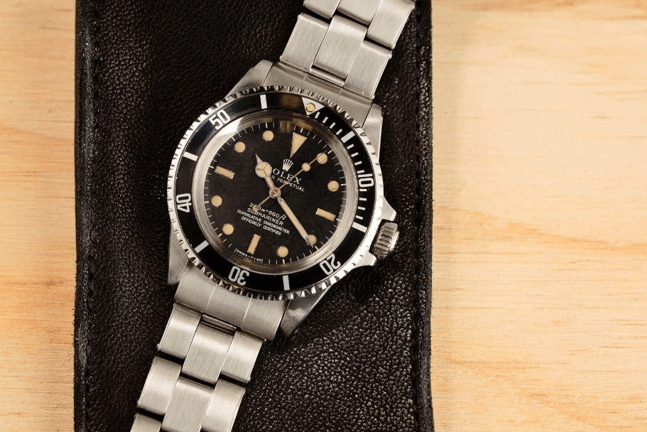 Actor Steve McQueen’s Rolex Submariner, Stainless Steel, Black Bezel and Dial Laying Flat on a Wooden Surface
