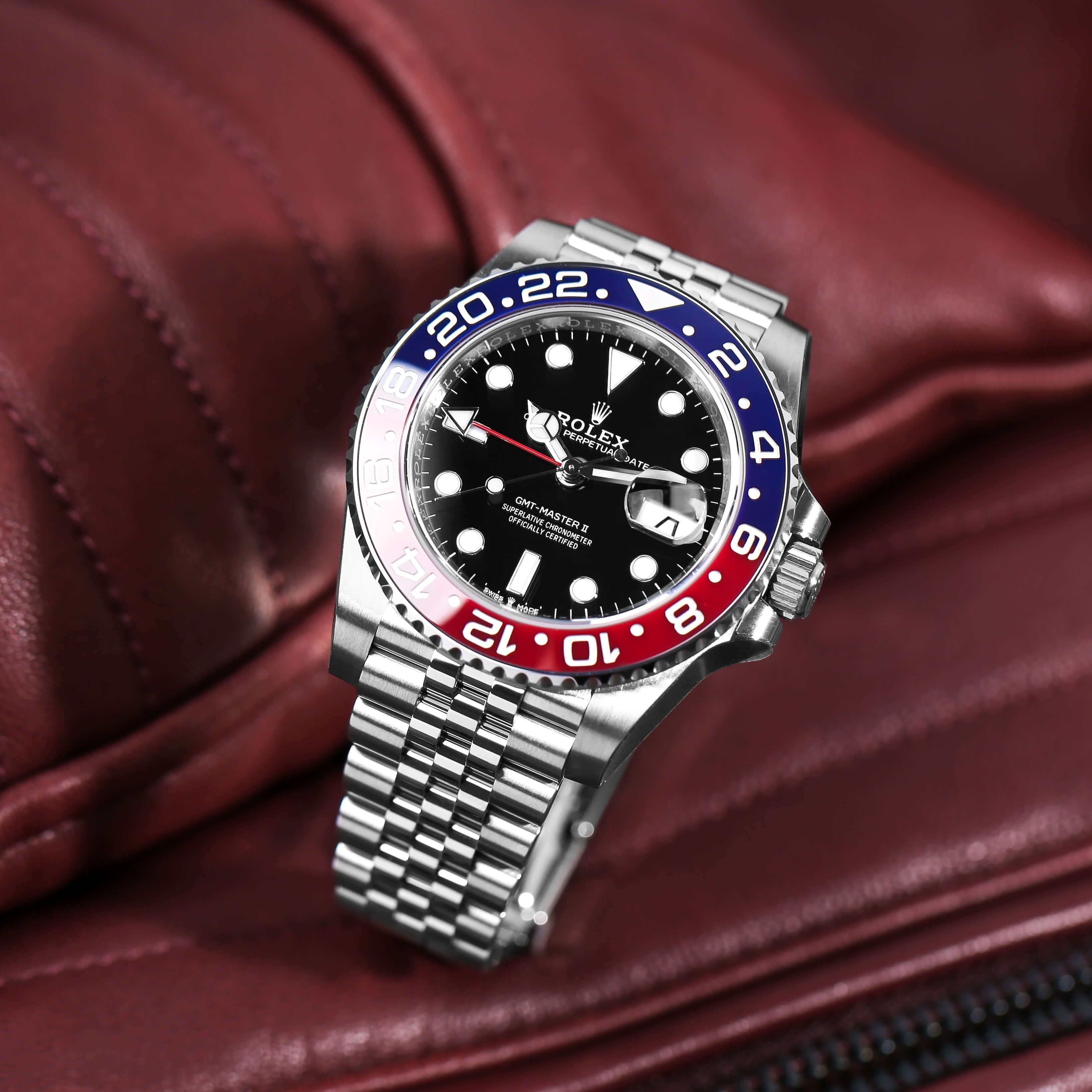 Rolex GMT-Master II, Pepsi Bezel, Black Dial on a Display Ring with a Red Leather Background