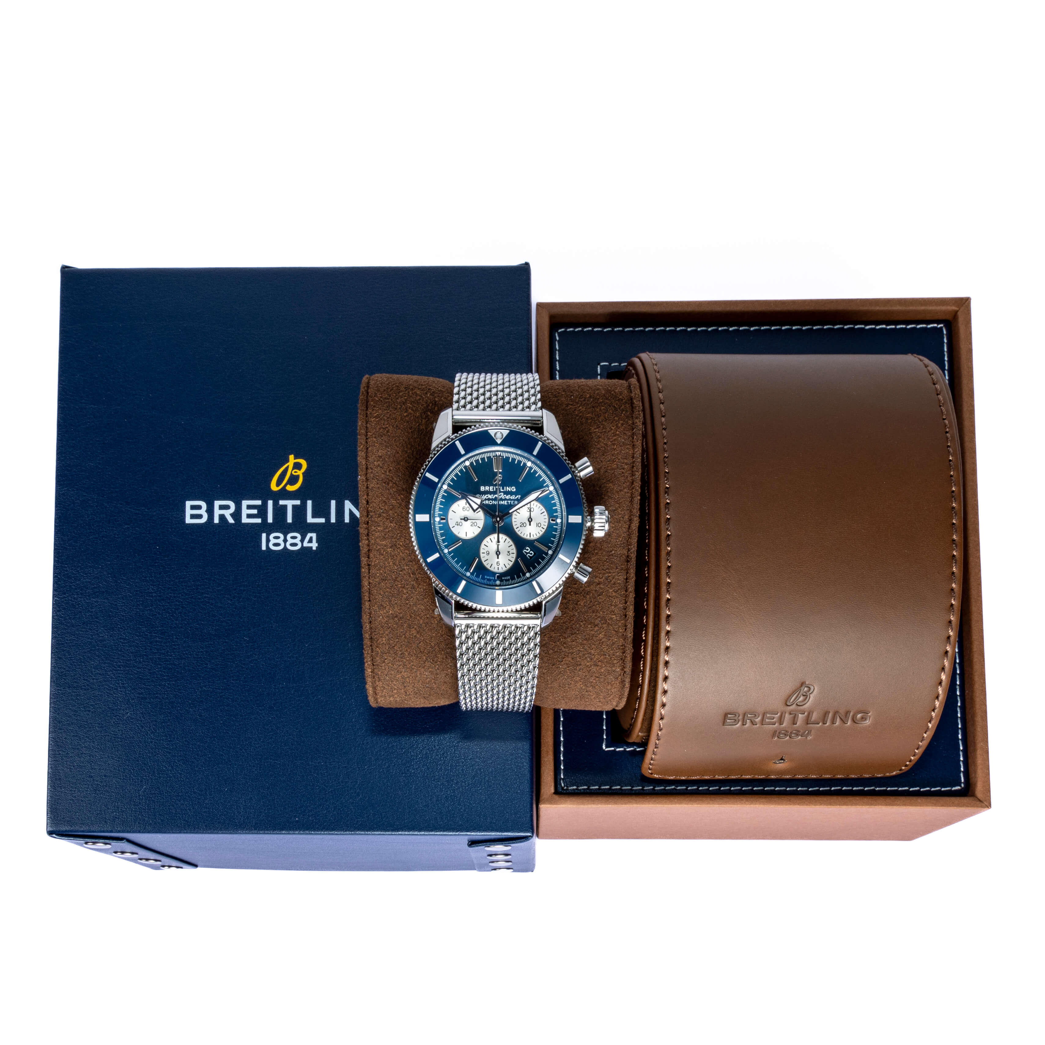 Stainless Steel Breitling Superocean-Heritage Blue Dial Wrapped Around a Watch Cushion Beside a Brown and Blue Breitling Box