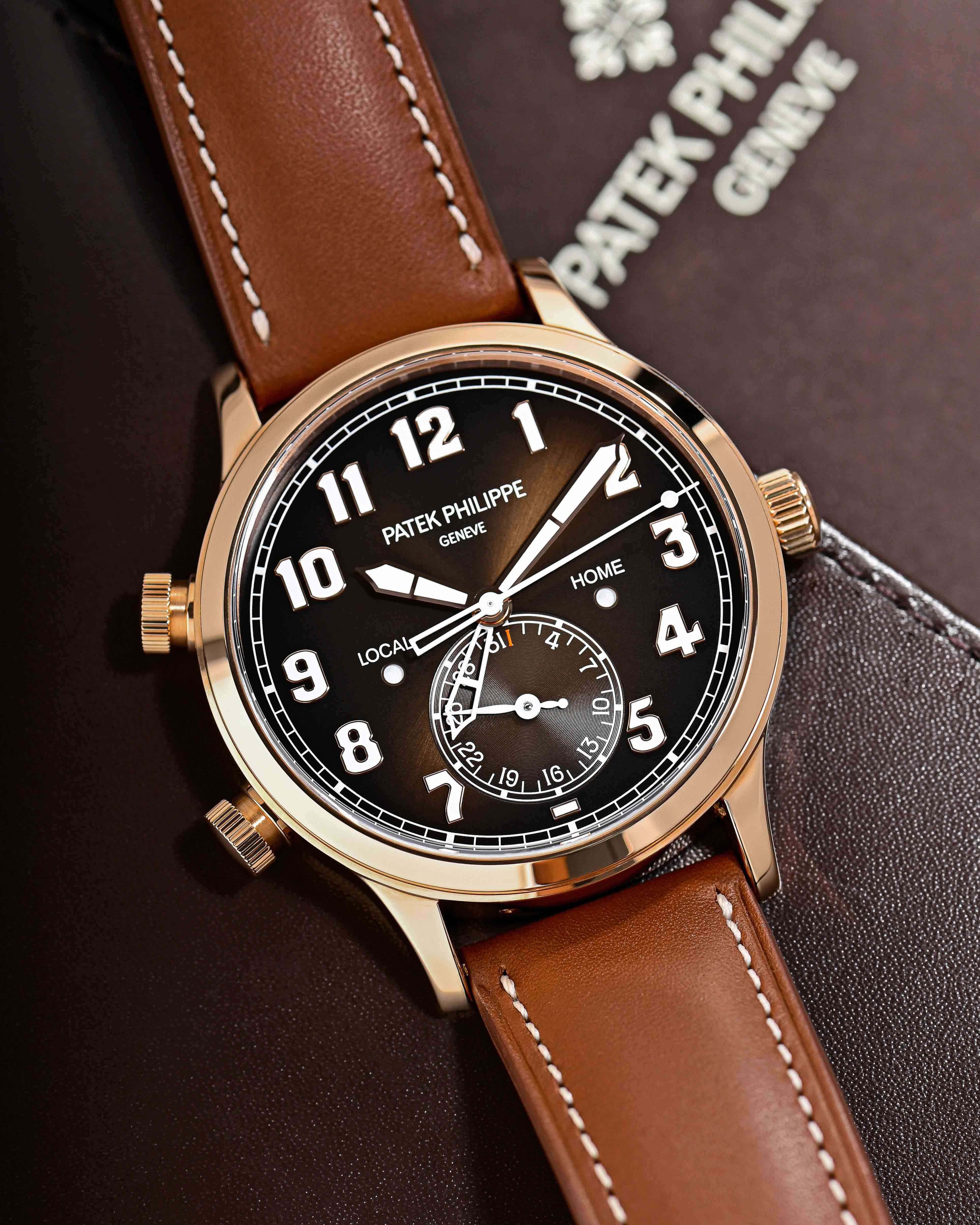 Patek Philippe Complications, Pilot Travel Time, 18K Rose Gold Case, Brown Dial, and Light Brown Leather Strap on a Brown Leather Background