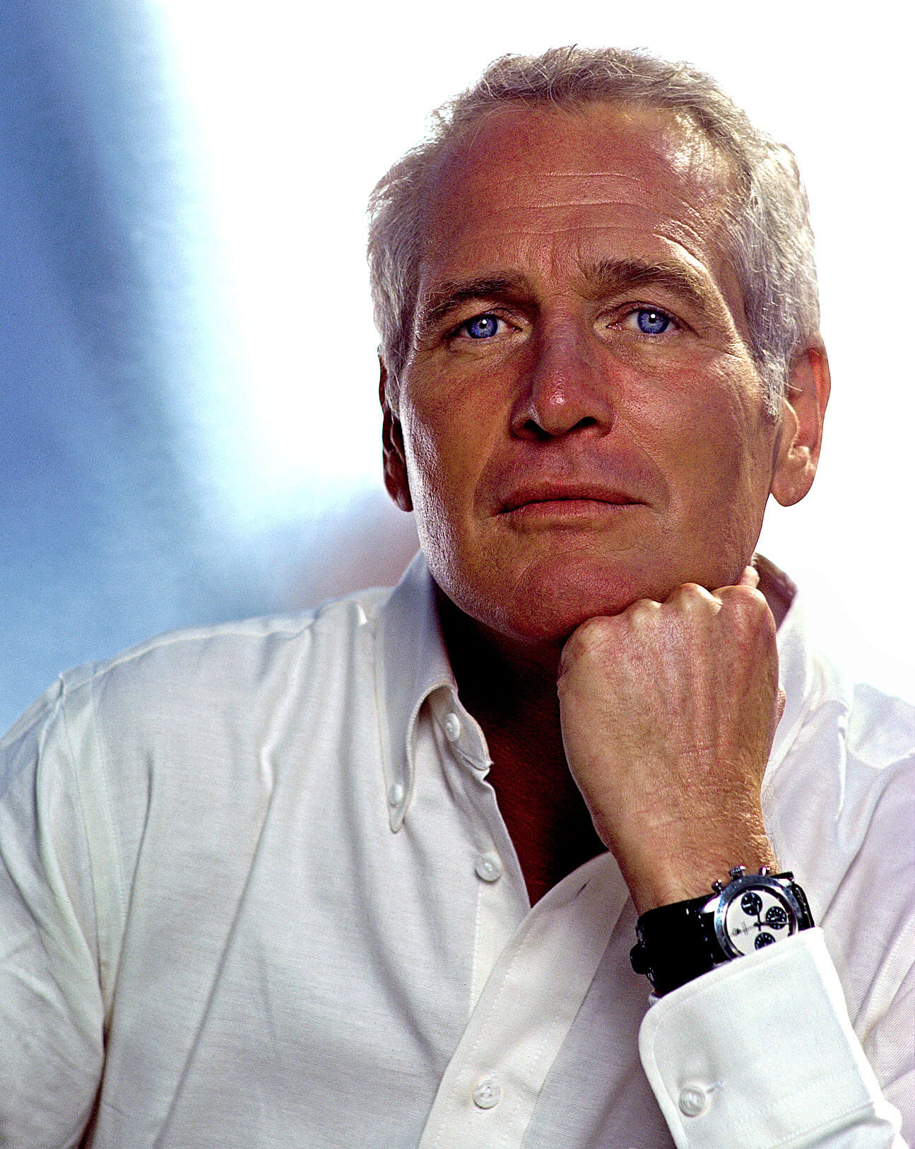 Paul Newman Wears a White Button-down Shirt and a Rolex Daytona with Black Leather Strap and White Dial