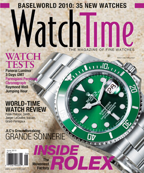 Rolex Timepiece with Green Dial and Bezel on a Sterling Silver Bracelet Laying on a Sandy Colored Magazine Cover with Black and Purple Text