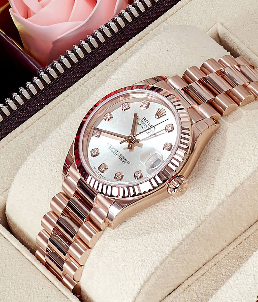 Rolex Datejust 36 with an Oystersteel and 18K Rose Gold 36 mm Case, Mother of Pearl Dial, and Flute, Rose Gold Bezel on a Tan Watch Display