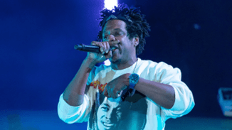 Jay-Z Singing into Microphone Wearing a Blue Sapphire Richard Mille Timepiece and a Bob Marley Shirt