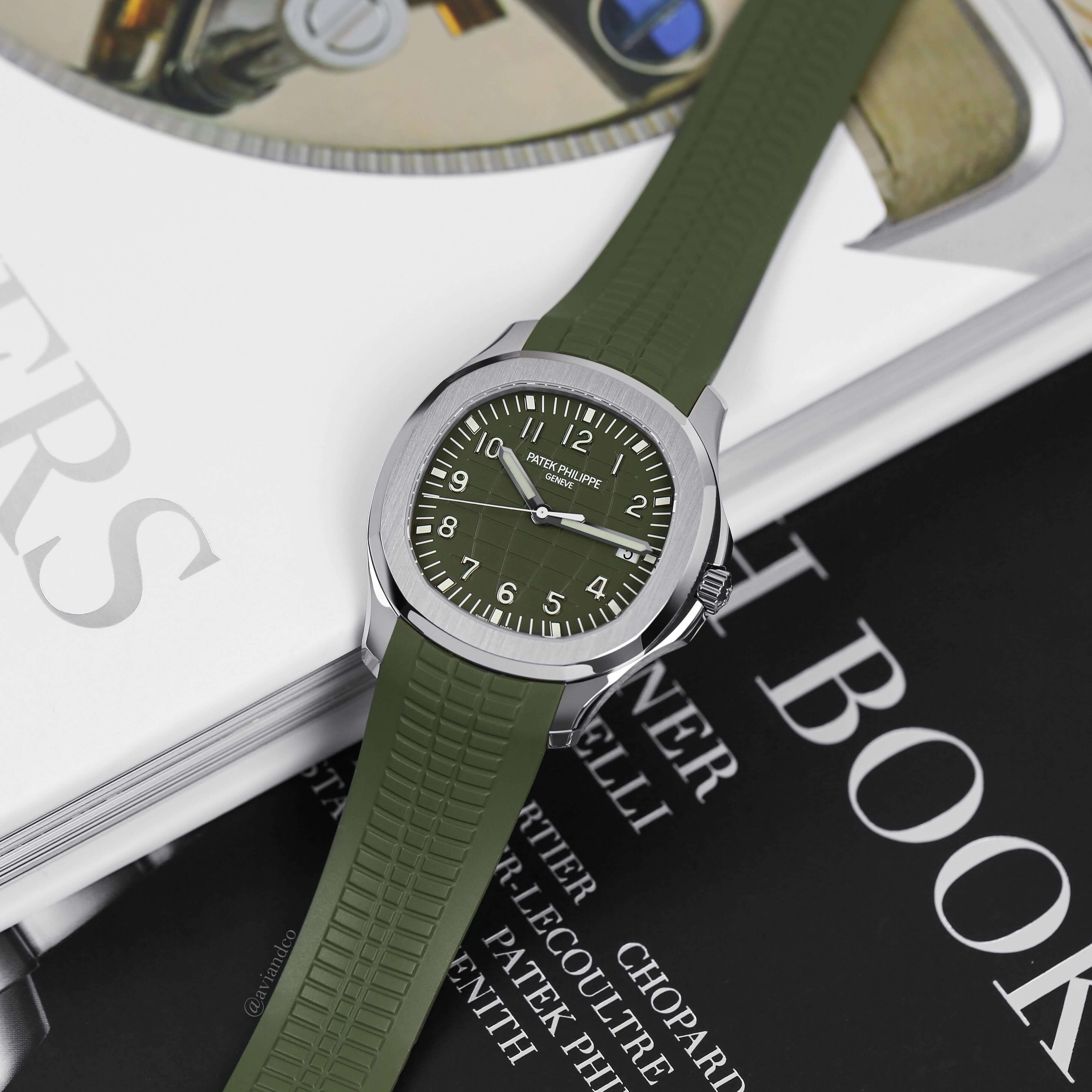 Patek Philippe Aquanaut, White Gold, Green Dial Lying Flat on a Luxury Watch Book