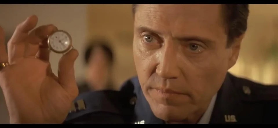 Movie Still from Pulp Fiction of Christopher Walken’s Character Holding a White Watch Dial with Gold Bezel