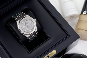 Audemars Piguet watch in a black box next to upscale beauty products