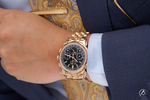 Patek Philippe Grand Complications, 18K Rose Gold, Black Index Dial on a man's wrist wearing a navy blue suit