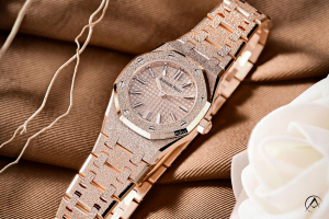 Audemars Piguet Royal Oak, 18K Rose Gold, Rose Dial, 23 mm taupe background photographed with white flower