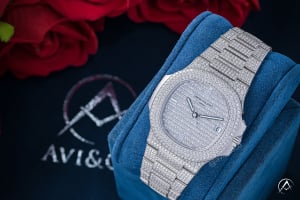 Patek Philippe Nautilus diamond pave watch in blue box with roses in the background