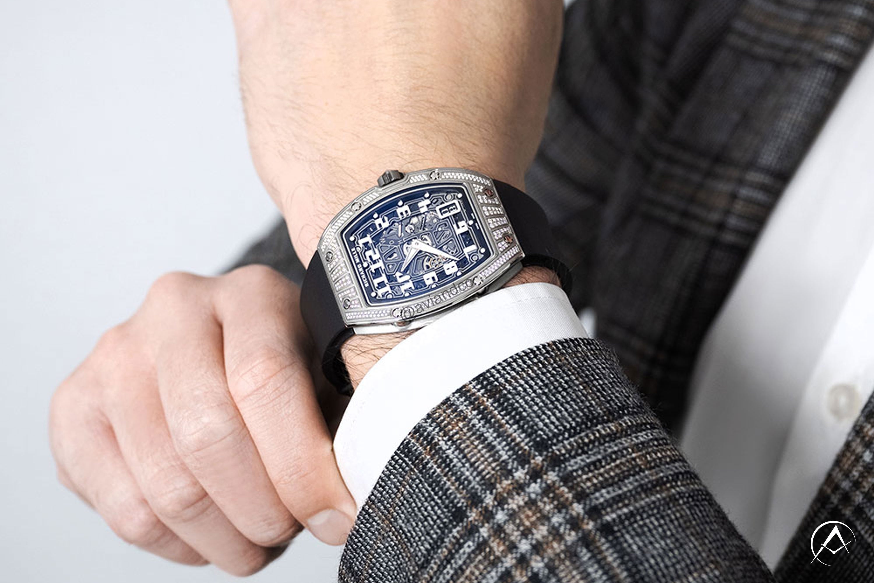 Richard Mille watch on the wrist of man wearing plaid suit