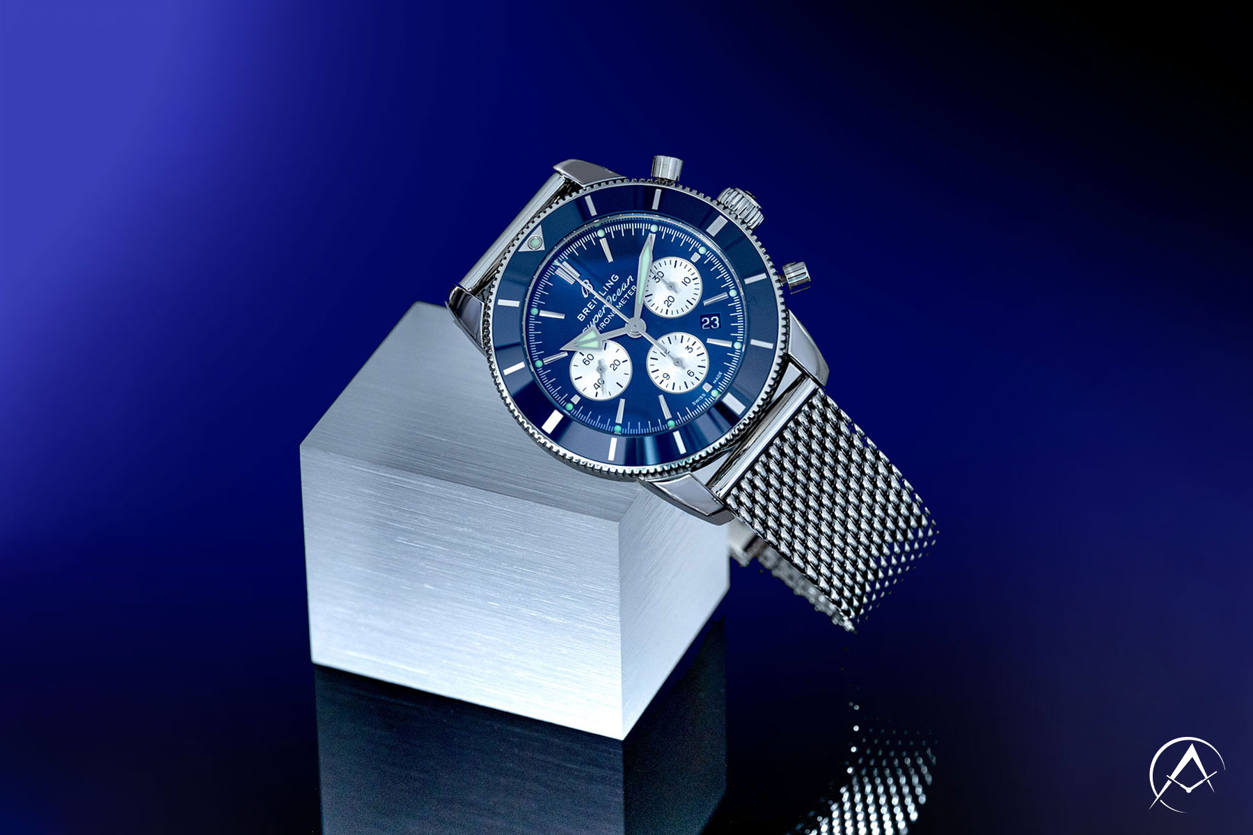 Sterling Silver Breitling Superocean-Heritage Timepiece with Blue Dial Leaning Against a White Block on a Reflected Background