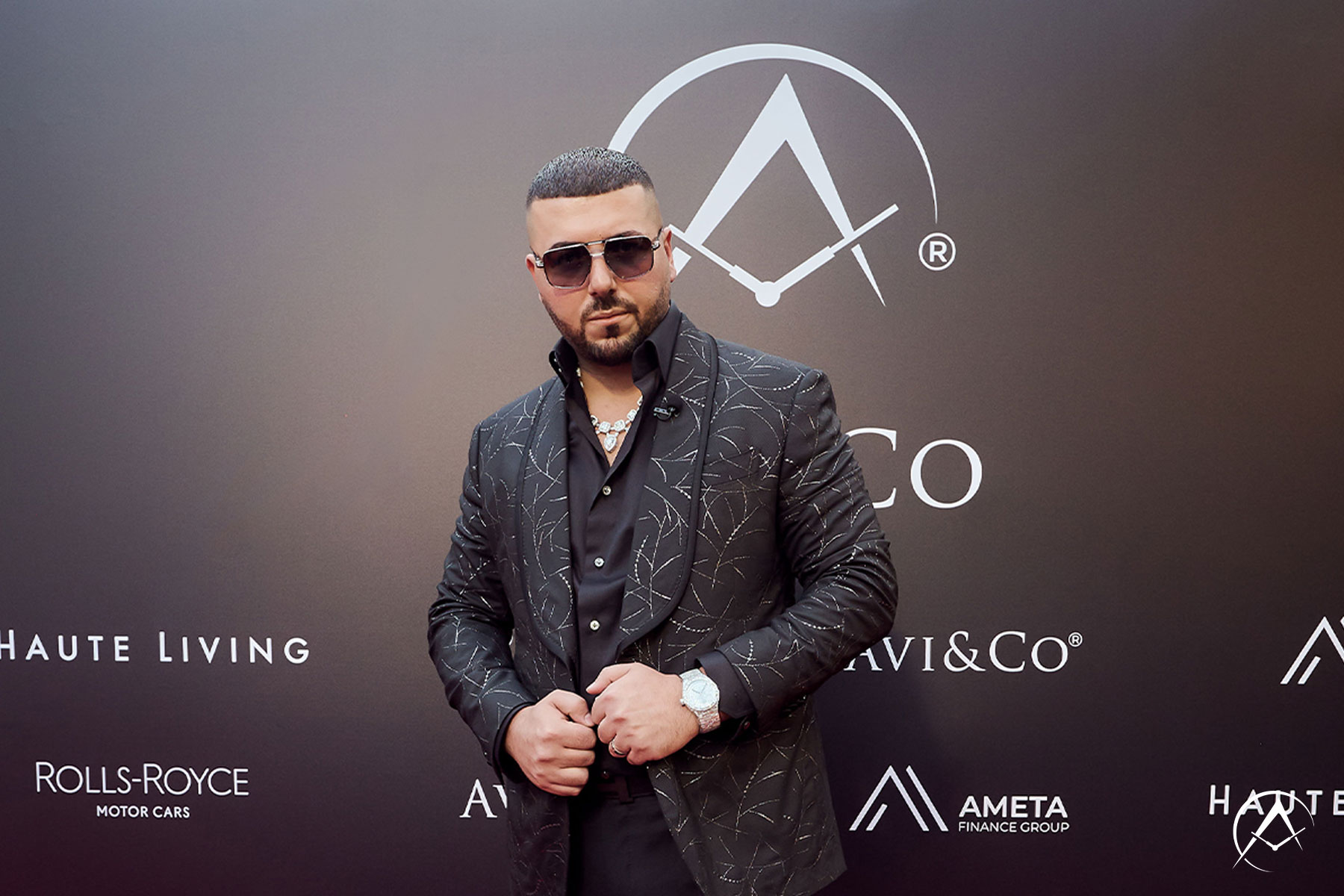 Avi Hiaeve, CEO and Founder of Avi & Co., Stands in Front of Step and Repeat with Companies such as Haute Living, Rolls Royce, and Ameta Finance Group