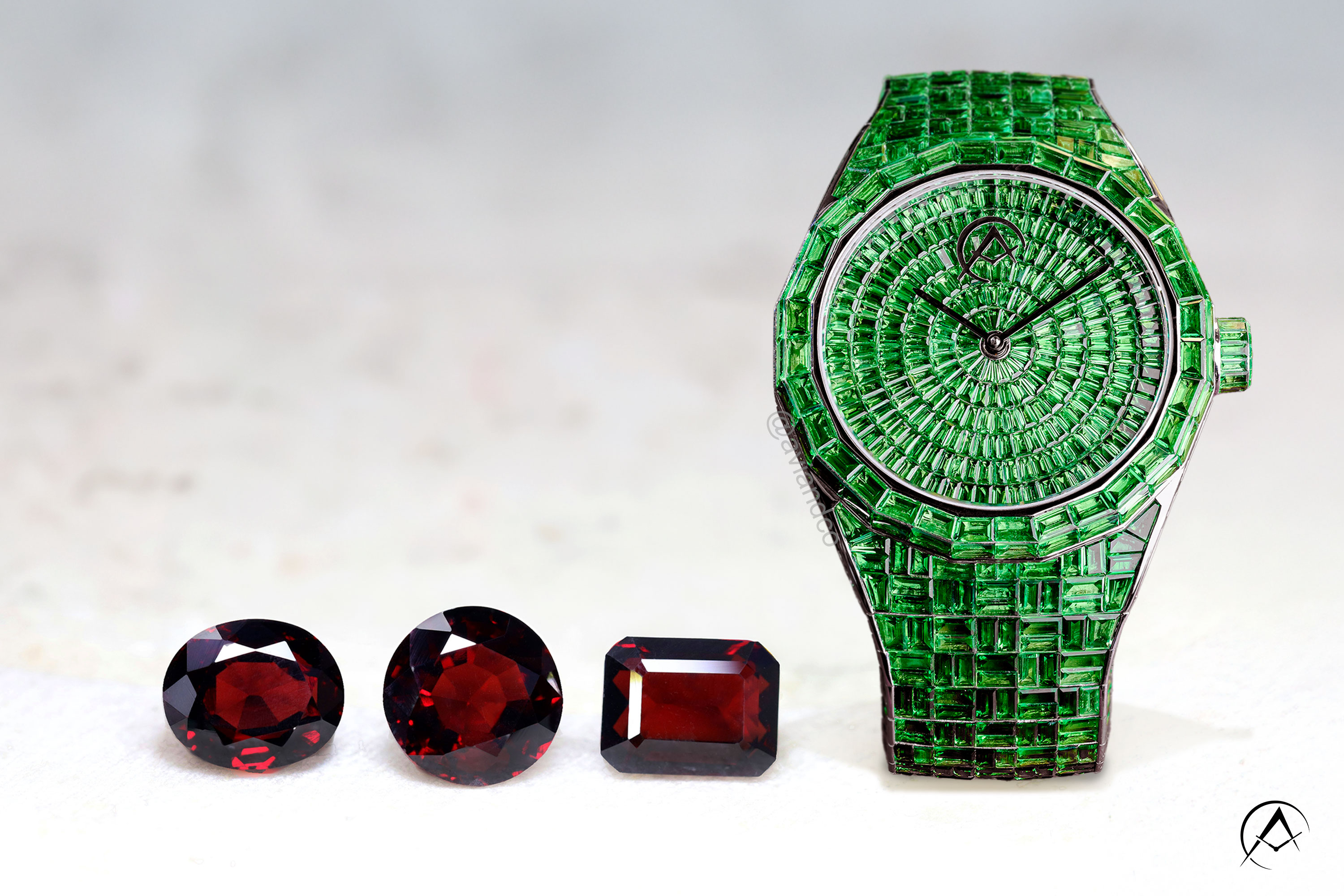 Avi & Co. green garnet watch alongside three red garnet stones, the January birthstone garnet