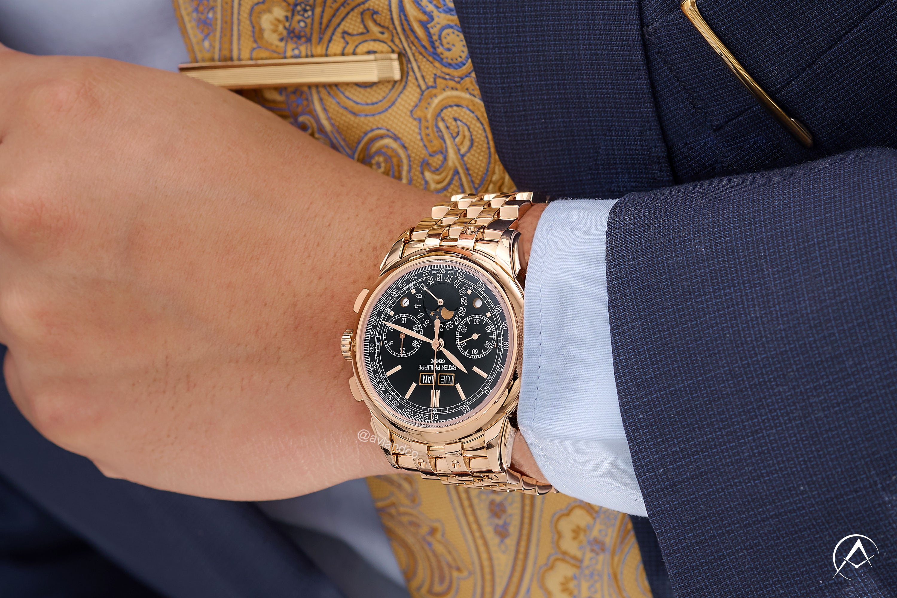 Patek Philippe Grand Complications, 18K Rose Gold, Black Index Dial on a man's wrist wearing a navy blue suit