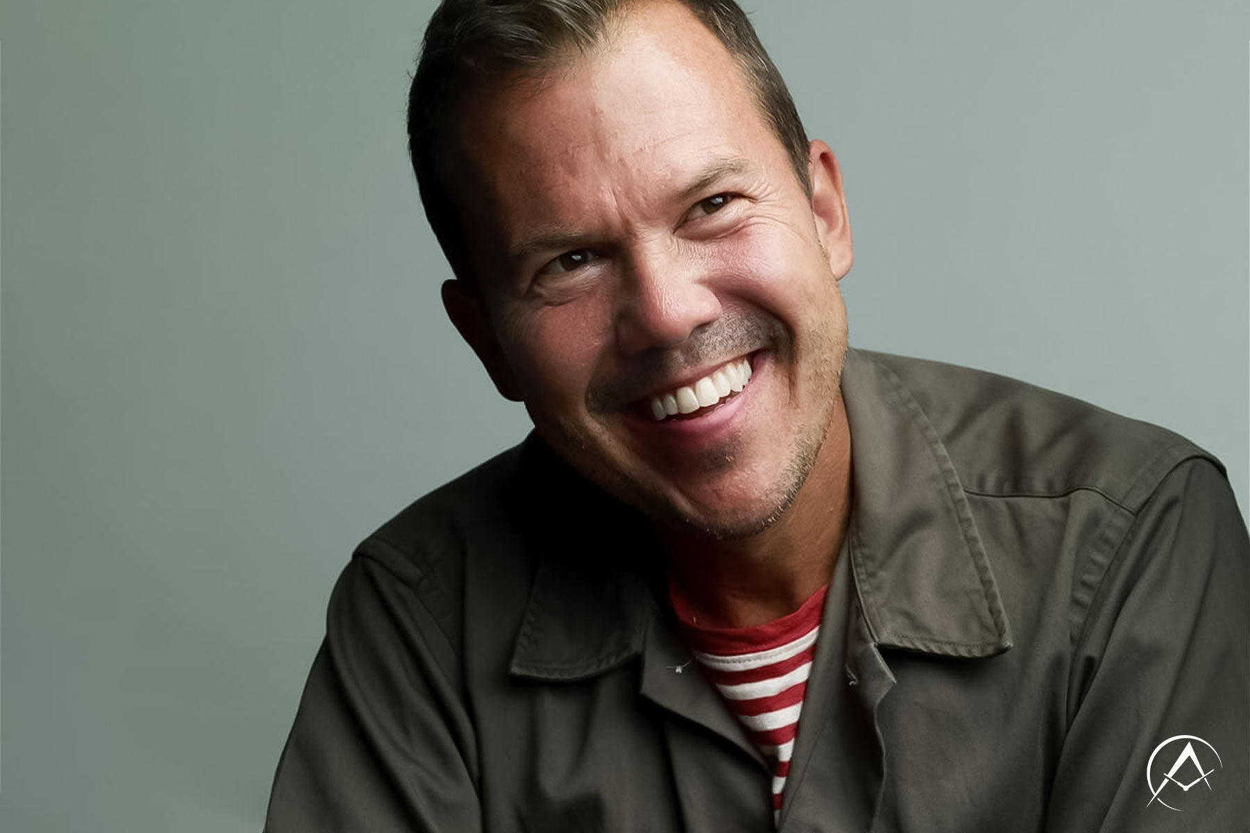 Watch Author and Collector Matt Hranek Smiles and Wears a Red and White Striped Shirt Underneath a Dark Brown Jacket