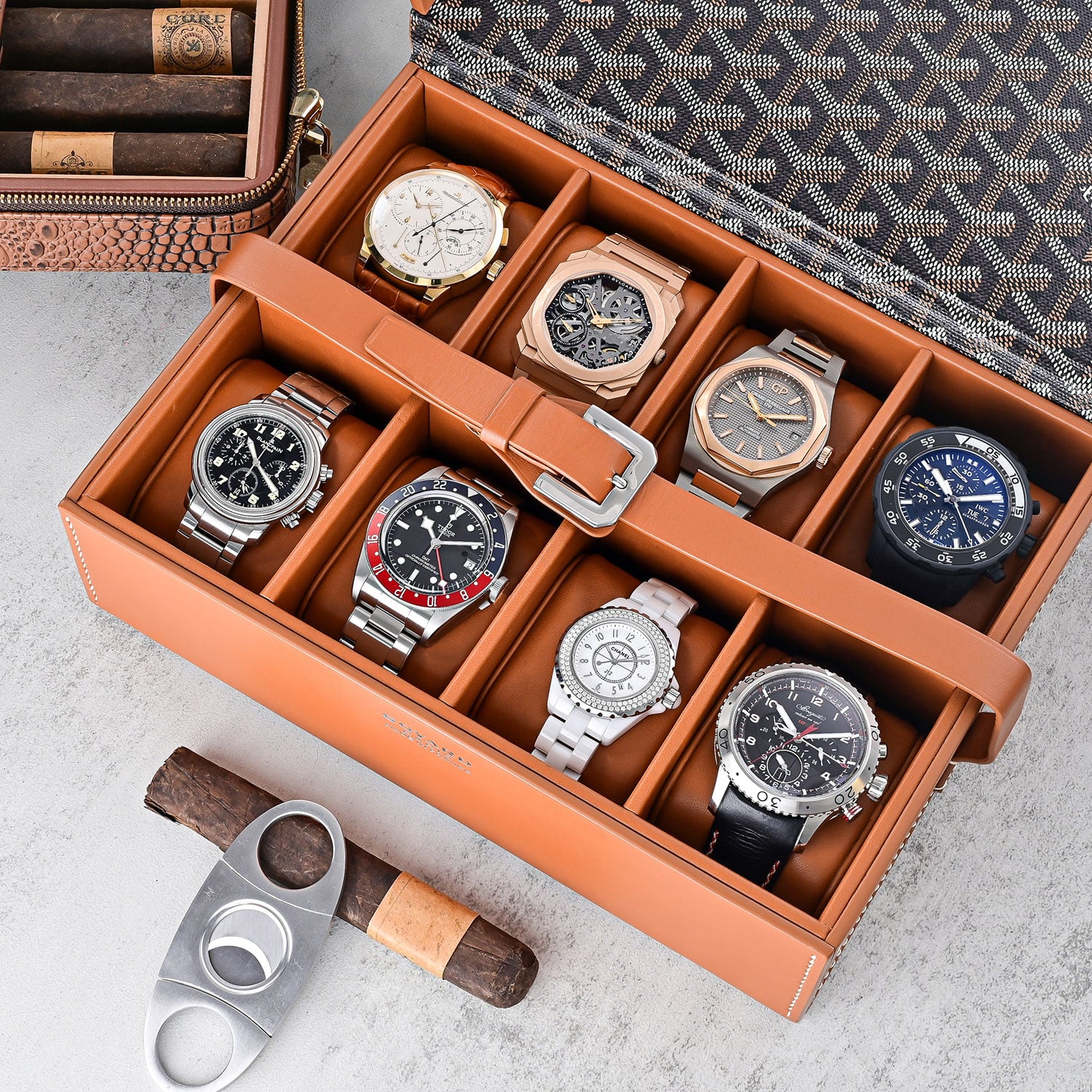 Luxury Timepieces Displayed in a Leather Watch Case Situated on a Table with Cigars and Cigar Cutter