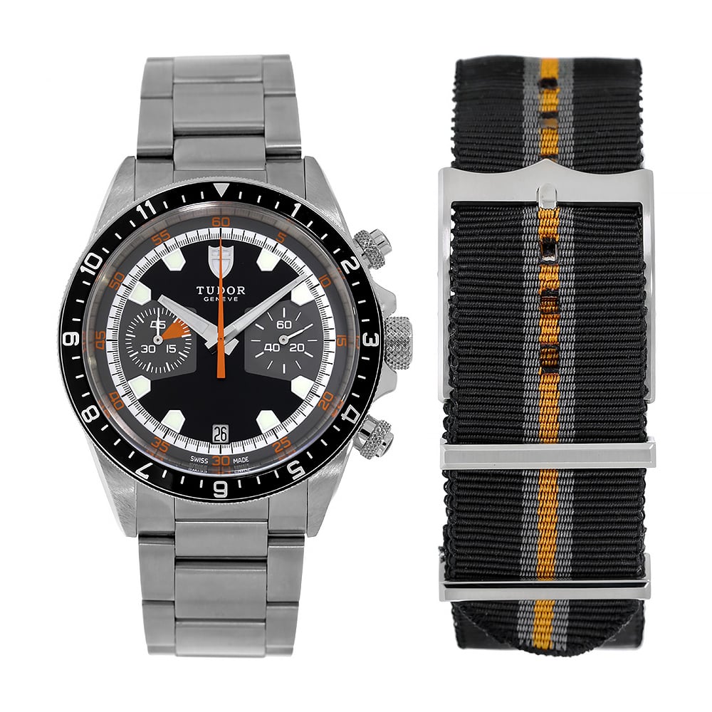 Stainless Steel Timepiece with Black Bezel and Black Dial Sits Beside a Black Strap with Orange Line on a White Background.