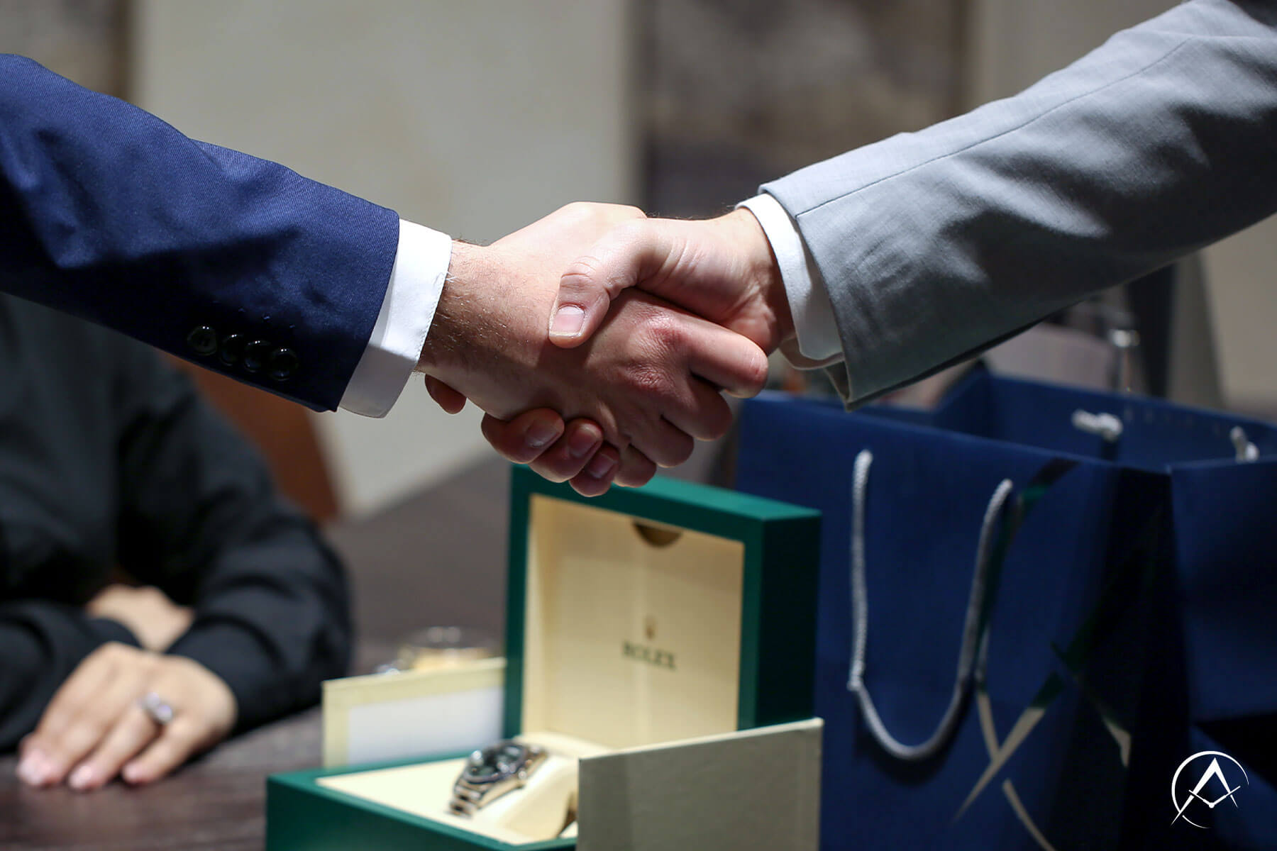 Two Men Shake Hands Over a Consignment Deal with a Rolex Watch in our New York City Showroom.