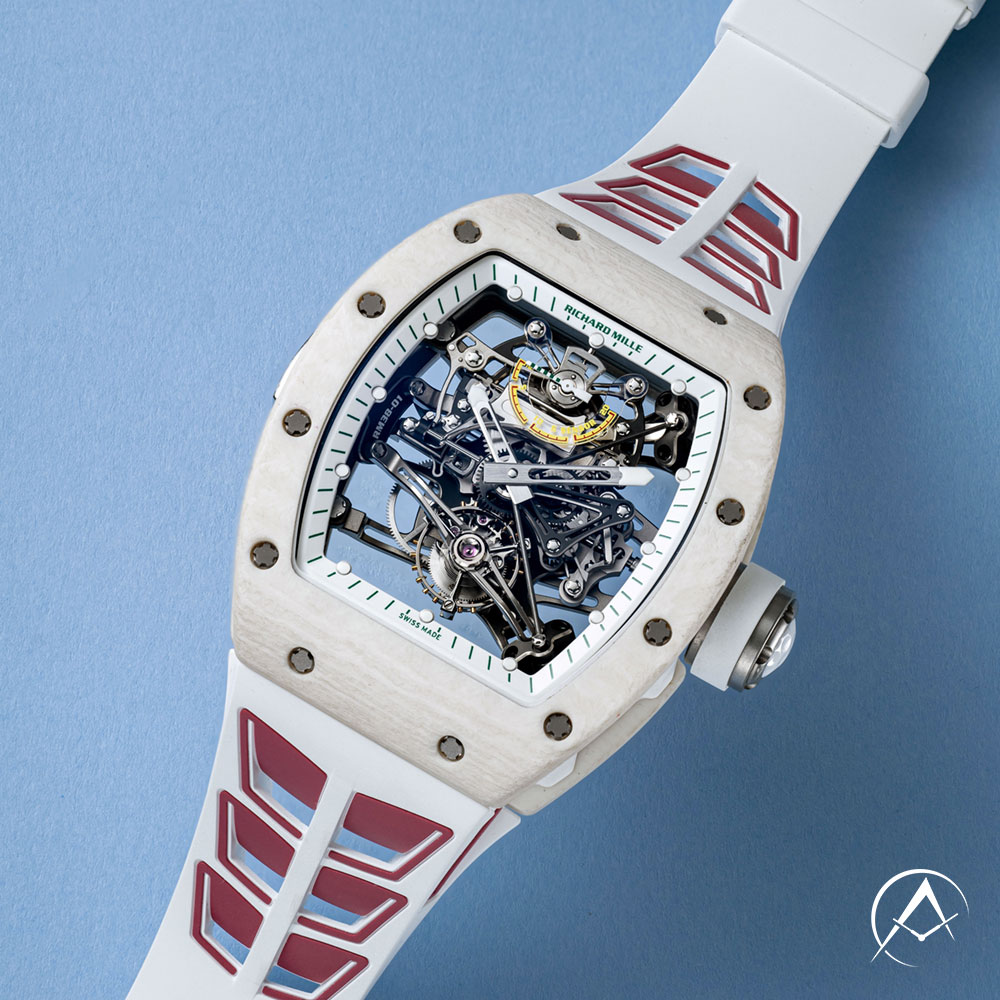 Richard Mille TPT Titanium 50 mm Timepiece with Transparent Dial Laying on a Blue Background.