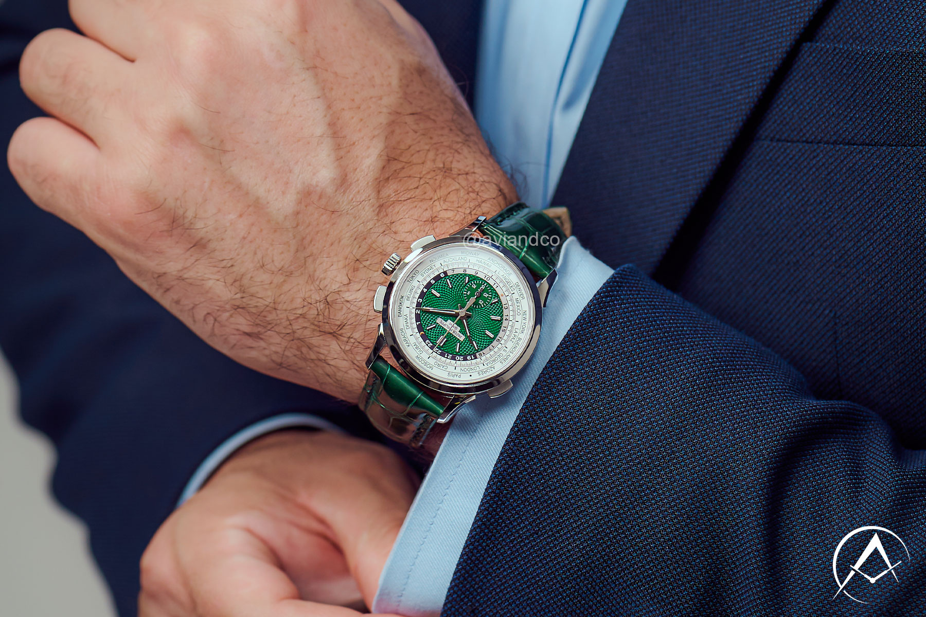 Patek Philippe Timepiece with Green Index Dial and Green Leather Strap Displayed on a Man’s Wrist Wearing a Navy Suit.