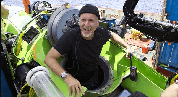 Filmmaker James Cameron sitting in a Green Sub, Wearing a Black T-shirt, Black Hat, and Sterling Silver Timepiece.