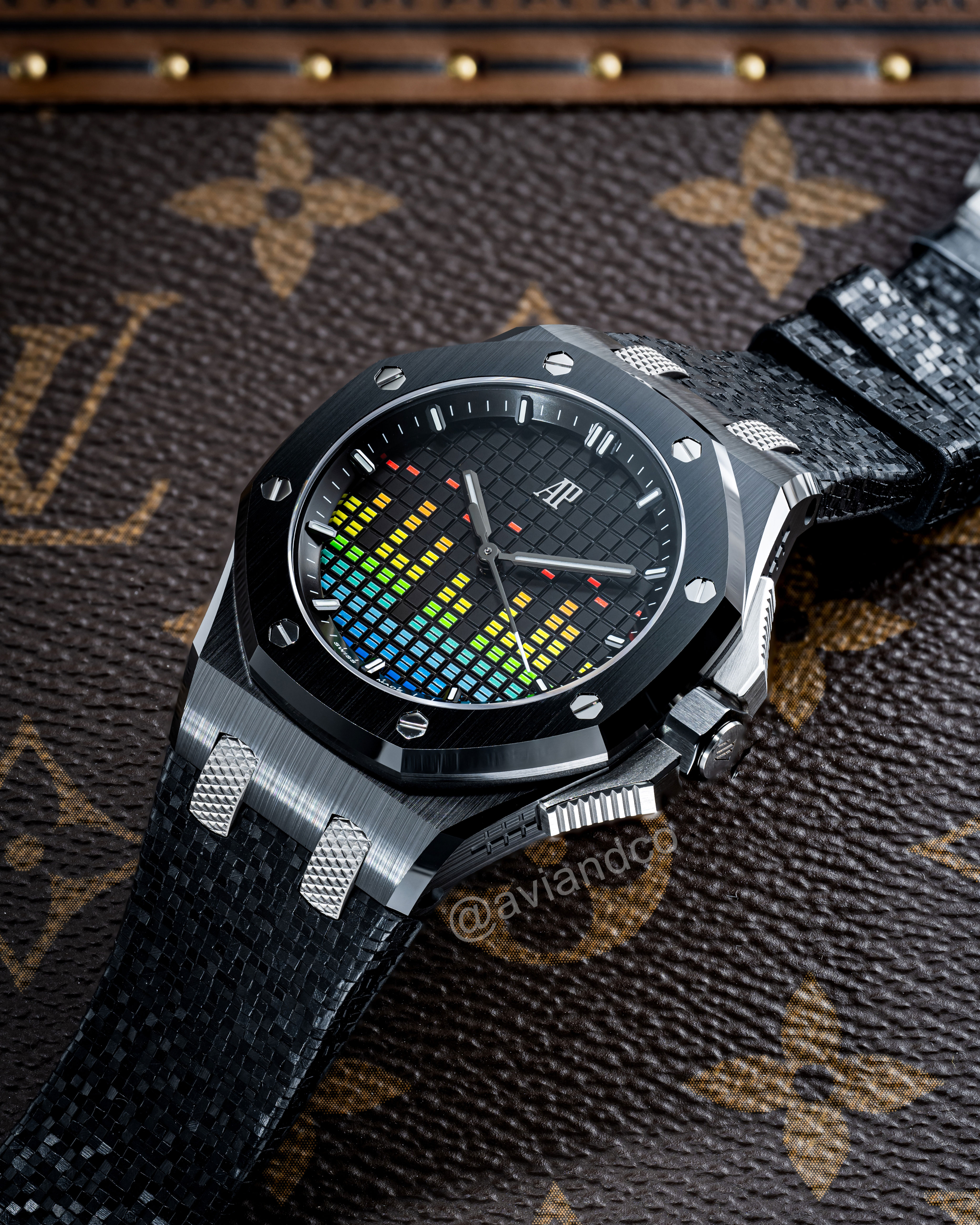 Black Ceramic Music Edition Timepiece with Black Rubber Strap Laid out on a Brown Louis Vuitton Background.
