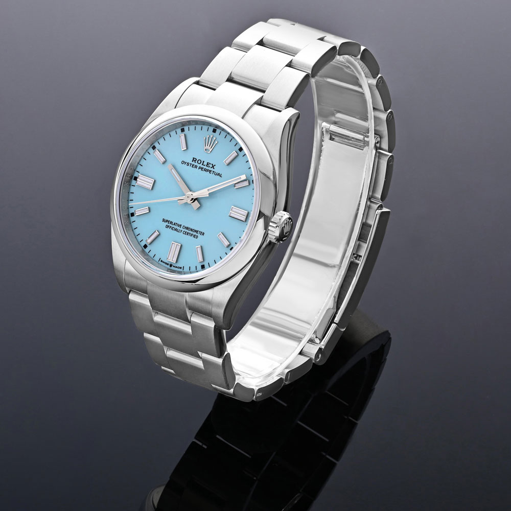 Stainless Steel Rolex Oyster Perpetual Timepiece with Turquoise Index Dial on a C-Ring with Gray Background.