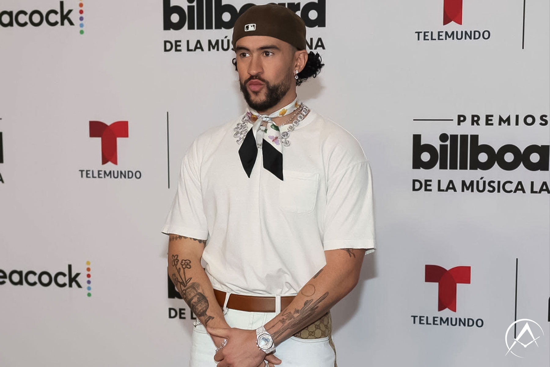 Man Wears White T-shirt, White Jeans, Gucci Belt, and Avi & Co. Diamond-Pave Jewelry at the Opening Ceremony of the Latin Music Awards.