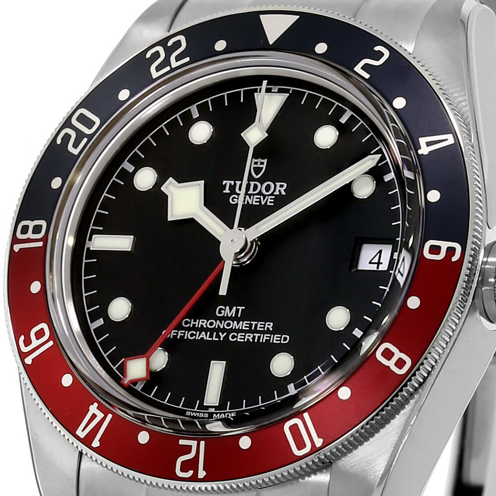 Close Up of Stainless Steel Case and Black Dial Timepiece with a Red and Blue Bezel.