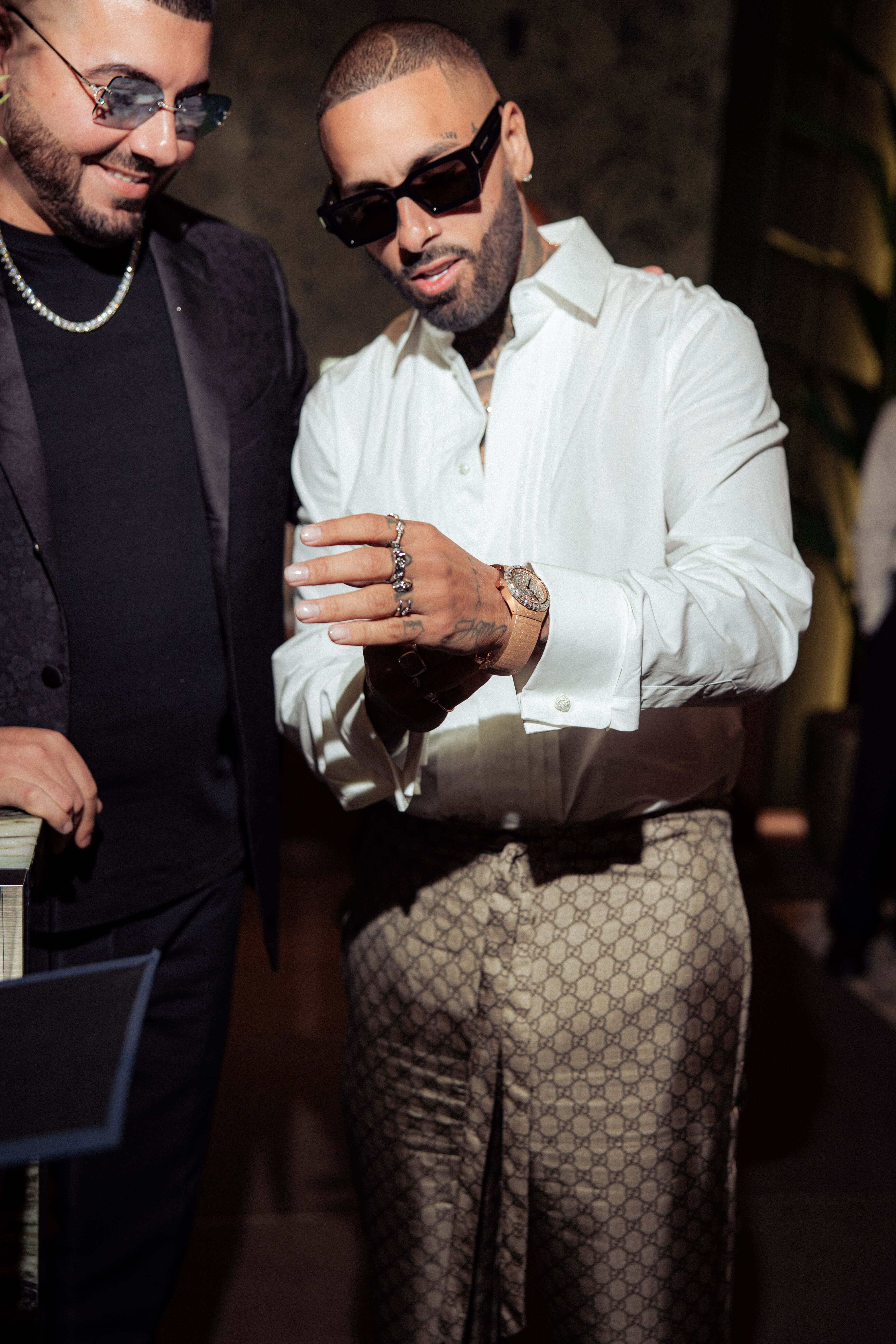 Man Wears New Luxury Watch in the Miami Boutique with Black Sunglasses, White Button-down Shirt, and Brown Pants.