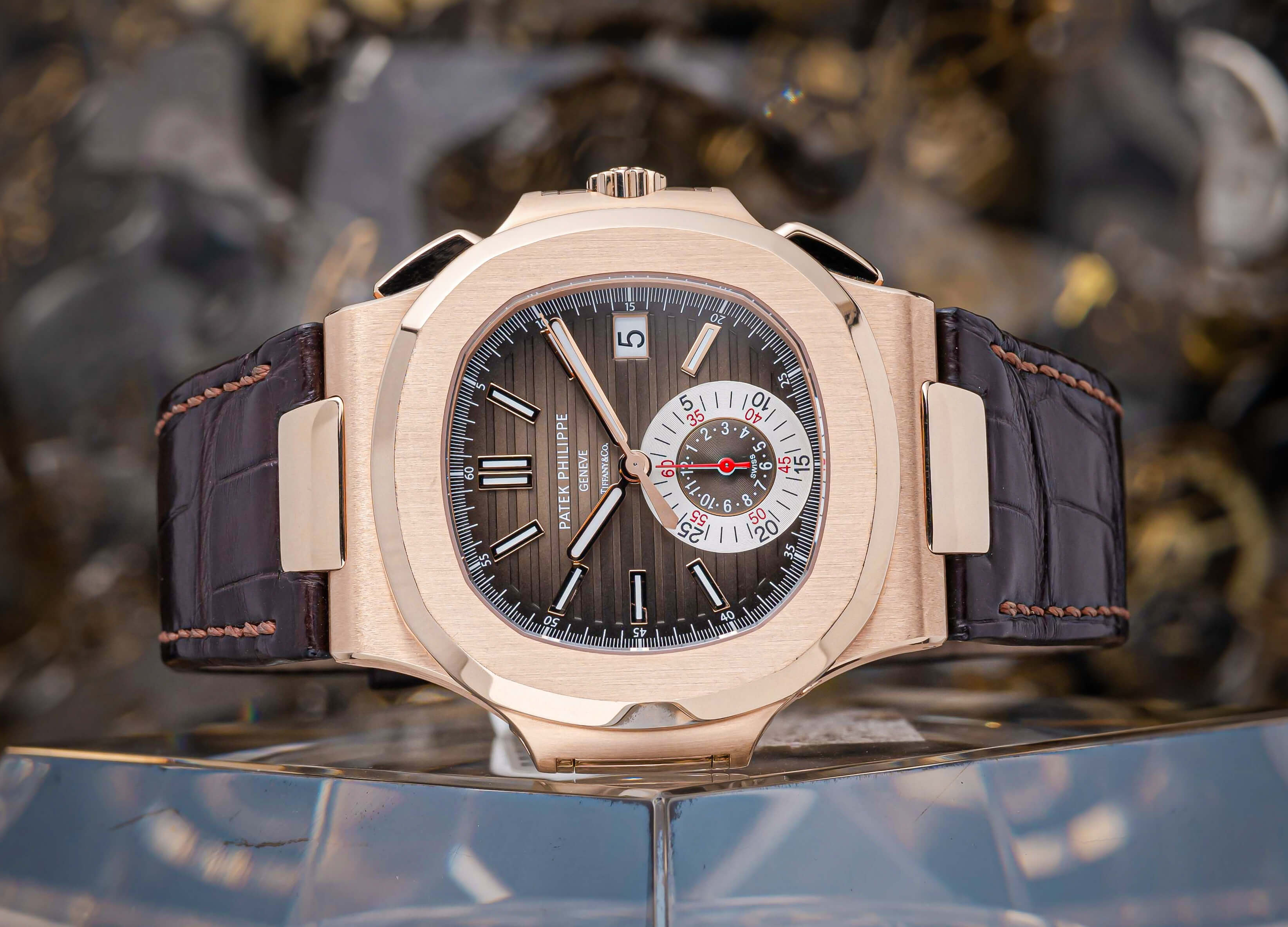 18K Rose Gold Patek Philippe Nautilus Chronograph with 40 mm Case, Brown Index Dial, Leather Bracelet, and Date Function.