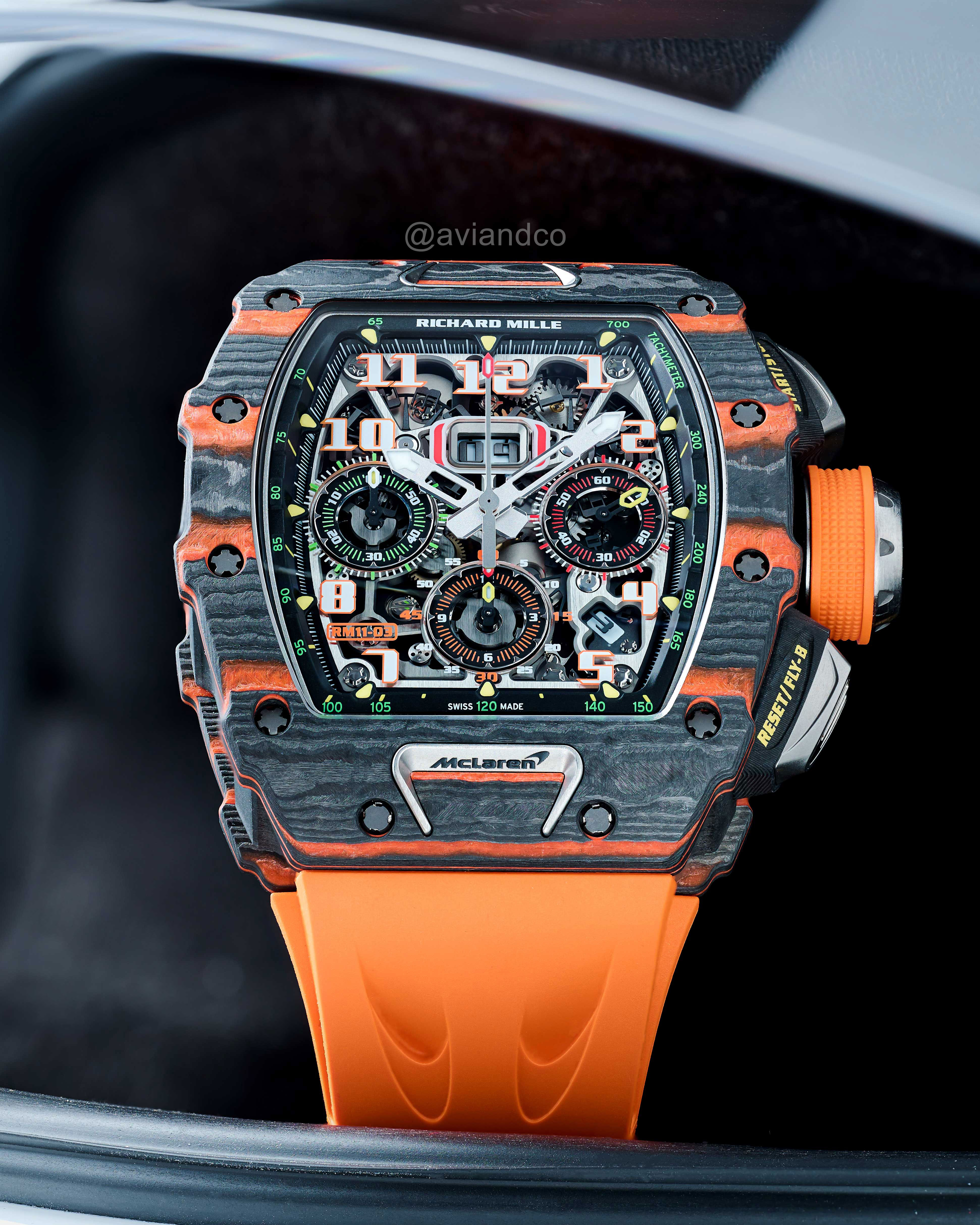 Carbon 44 mm Timepiece Assembled with Quartz TPT Bezel and Orange Rubber Strap and Skeleton Dial on a Black Background.