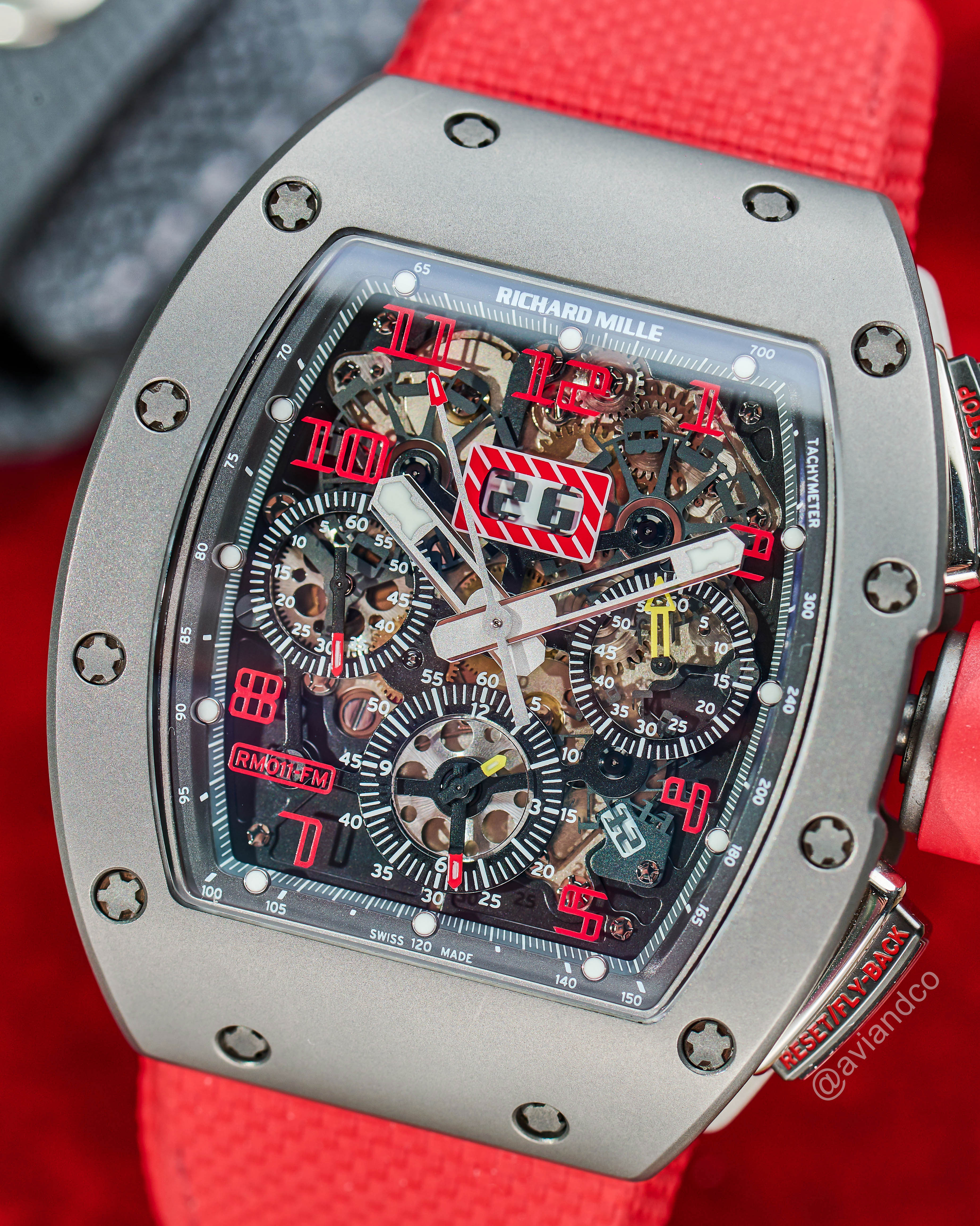 Close-up of Richard Mille Timepiece with Red Numbers and Red Strap.