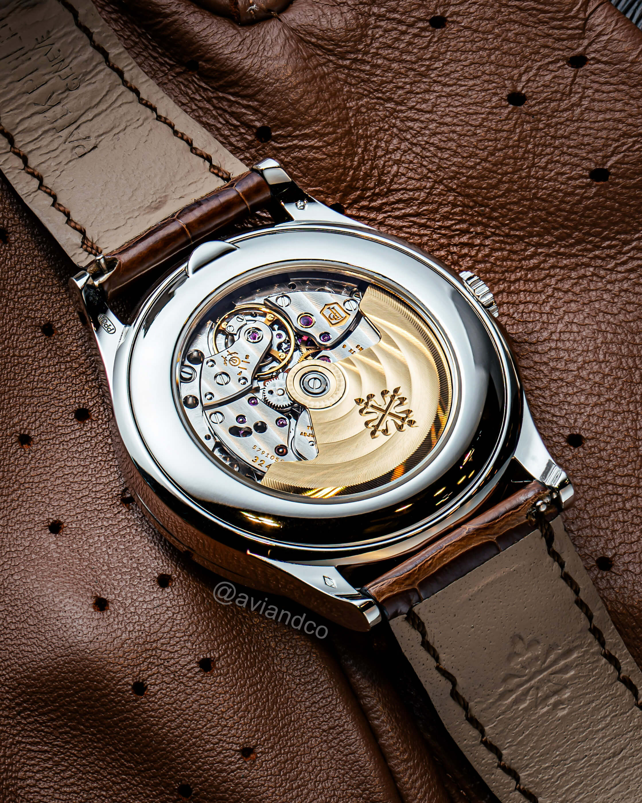 Back of 39.5 mm Patek Philippe Timepiece with Perpetual Calendar and Brown Leather Bracelet on a Brown Leather Background.