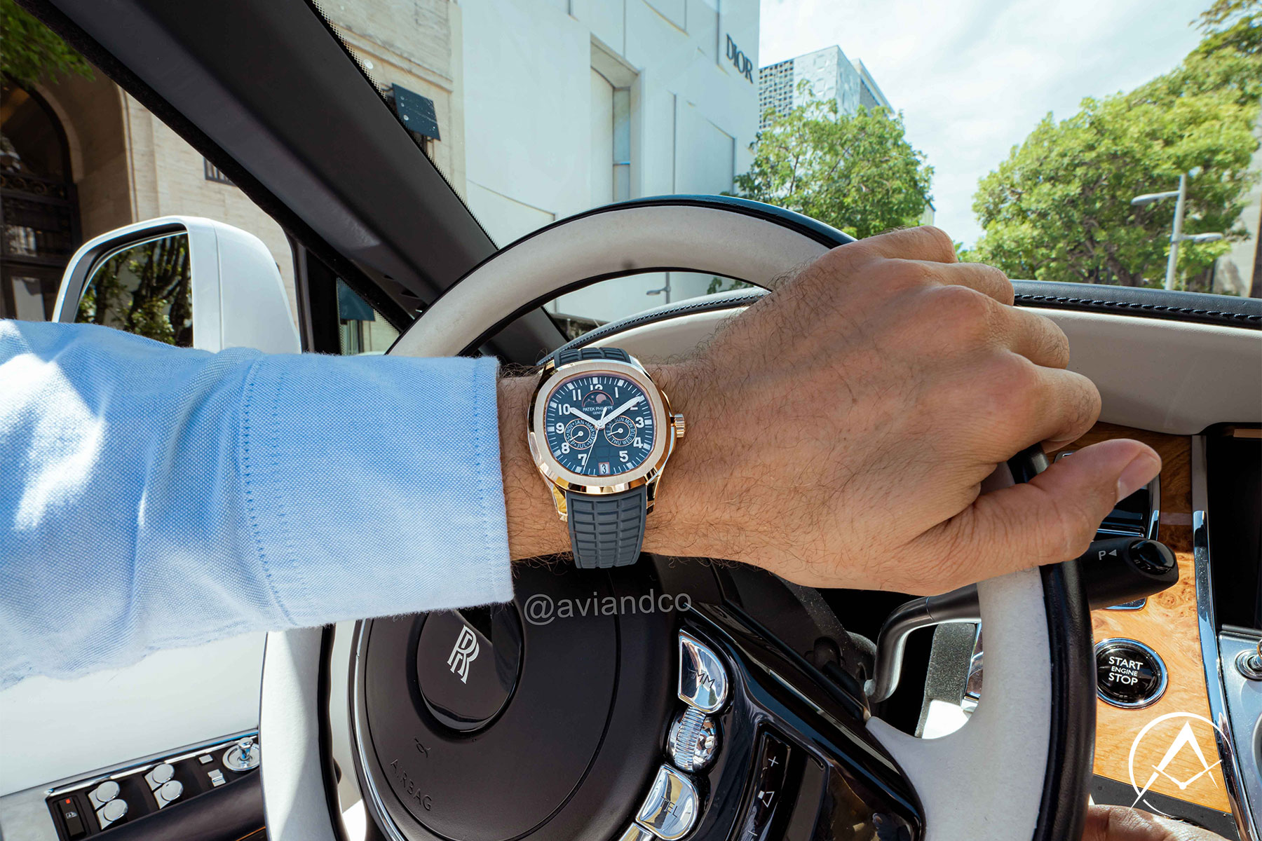 Blue Luxury Timepiece on Man’s Wrist Wearing a Light Blue Button-down Driving a Rolls-Royce Car in Miami.