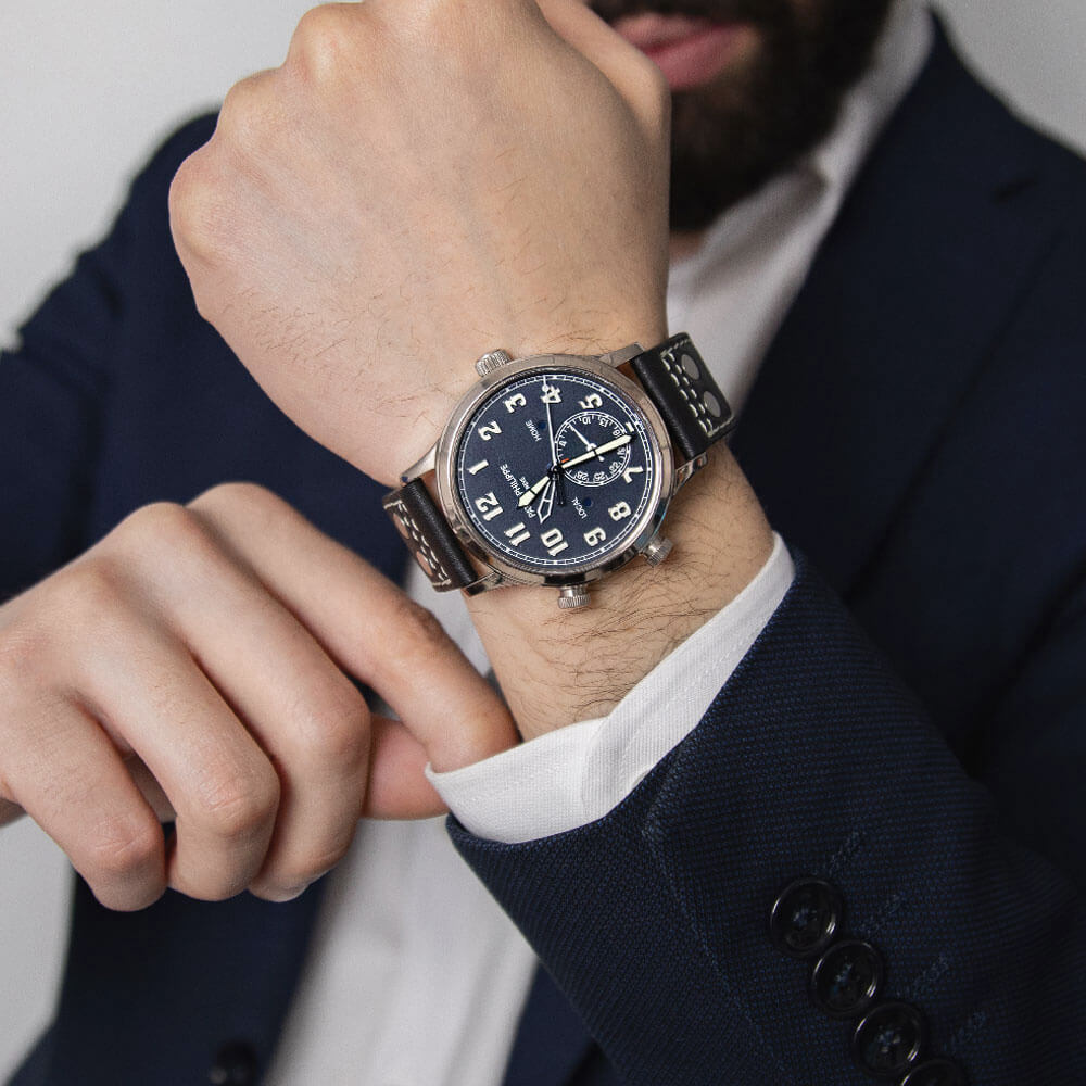 42 mm 18K White Gold Patek Philippe Calatrava with Blue Dial, Arabic Numerals, Leather Bracelet, and GMT Function Displayed on a Man’s Wrist.