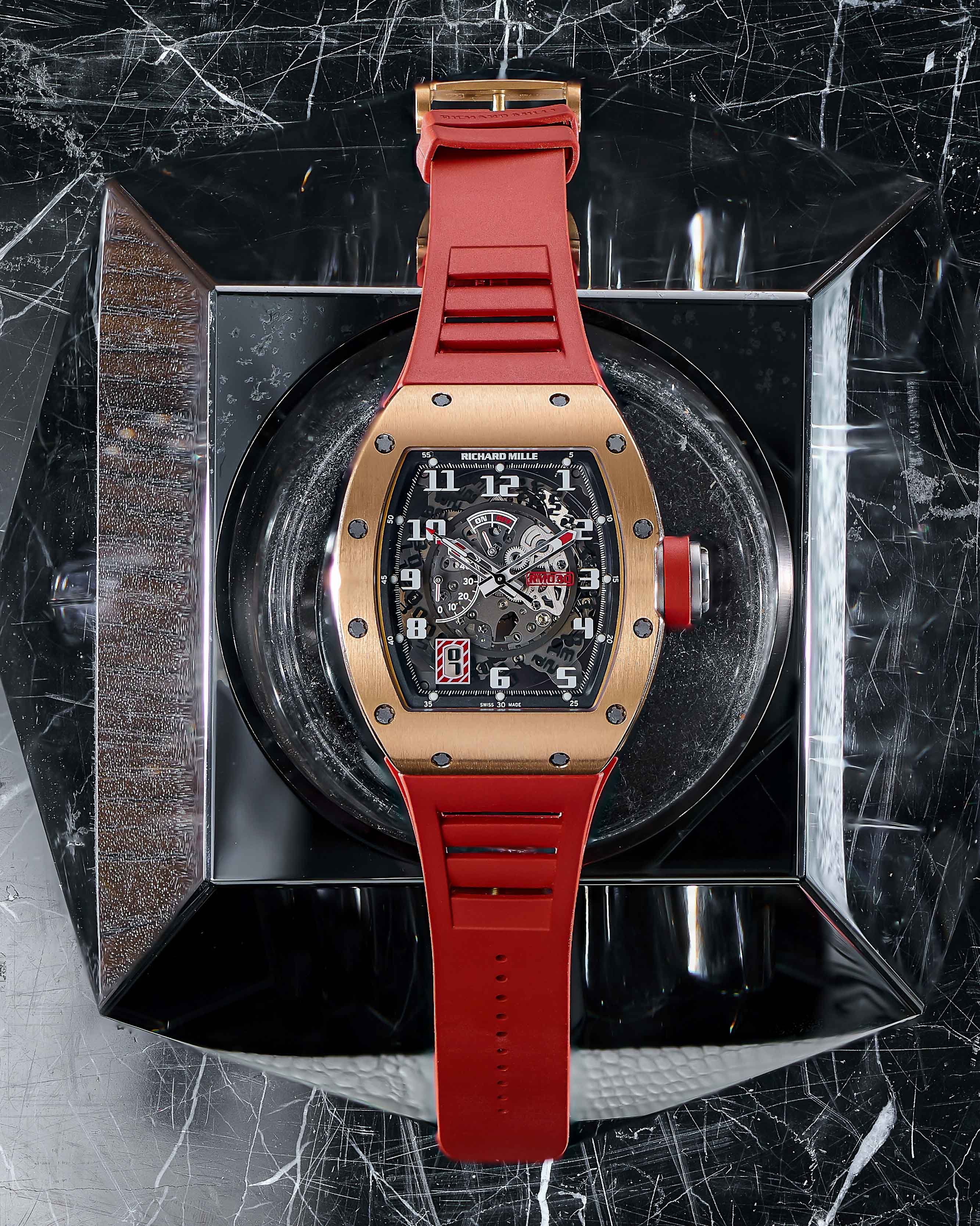 18K Rose Gold and Titanium 42 mm Case with Transparent Dial, Arabic Hour Markers, Red Rubber Bracelet, Date Function, and Power Reserve Display.