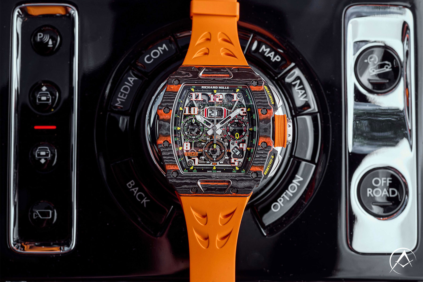 Carbon 44 mm Timepiece Assembled with Quartz TPT Bezel and Orange Rubber Strap Lying Out Inside of a Car.