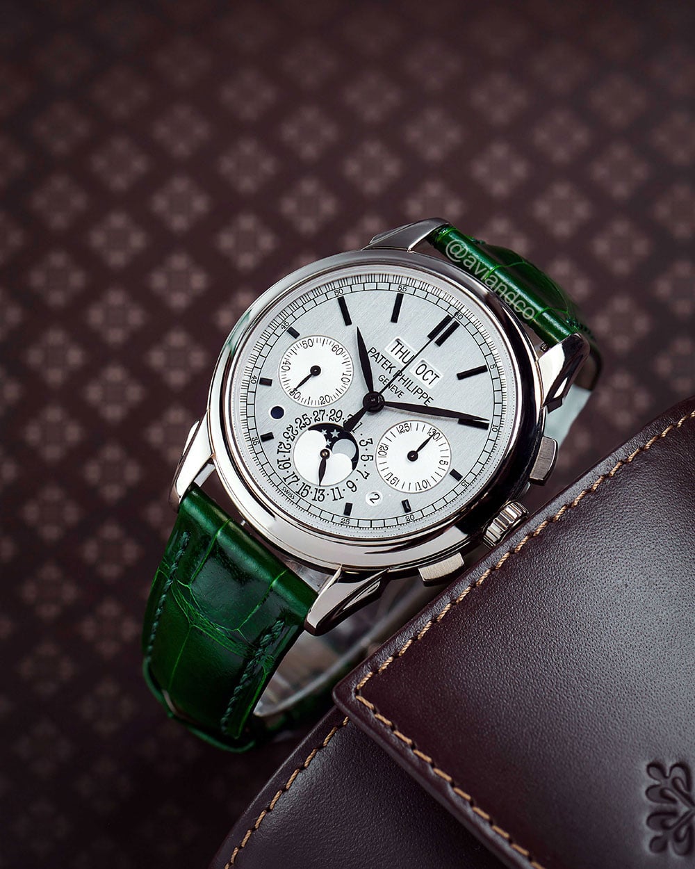 Perpetual Calendar Luxury Watch with 18K White Gold 41 mm Case, Silver Dial, Fixed Bezel, and Green Leather Strap Displayed on a C-ring.