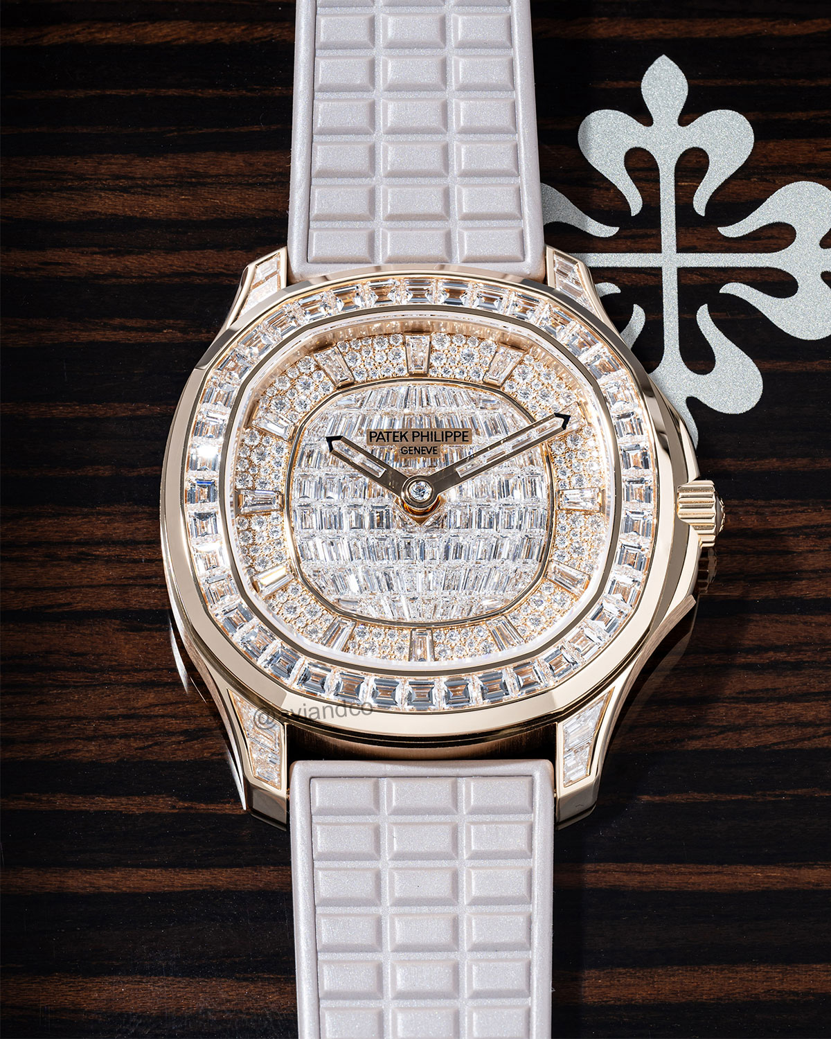 Rose Gold Patek Philippe Aquanaut Timepiece with Gem-set Bezel Displayed on a C-Ring with a Black Background.