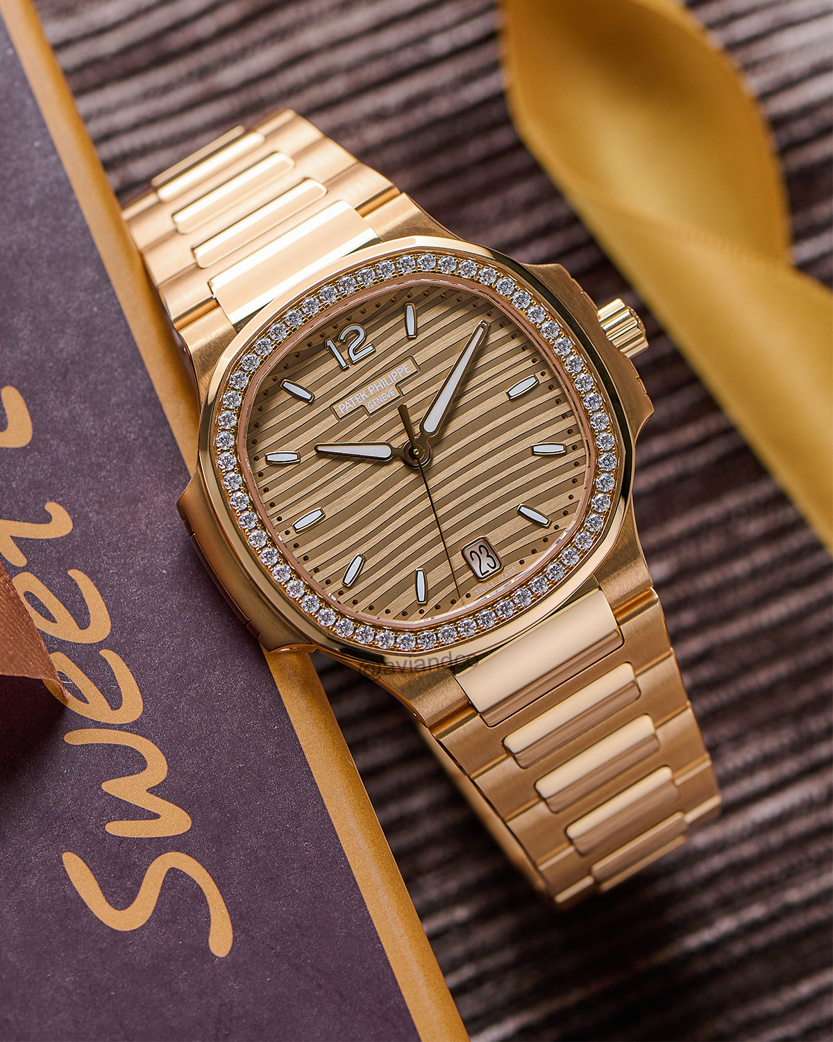 White Gold Gem-Set Patek Philippe Nautilus Timepiece Displayed on a C-Ring with a Black Background.