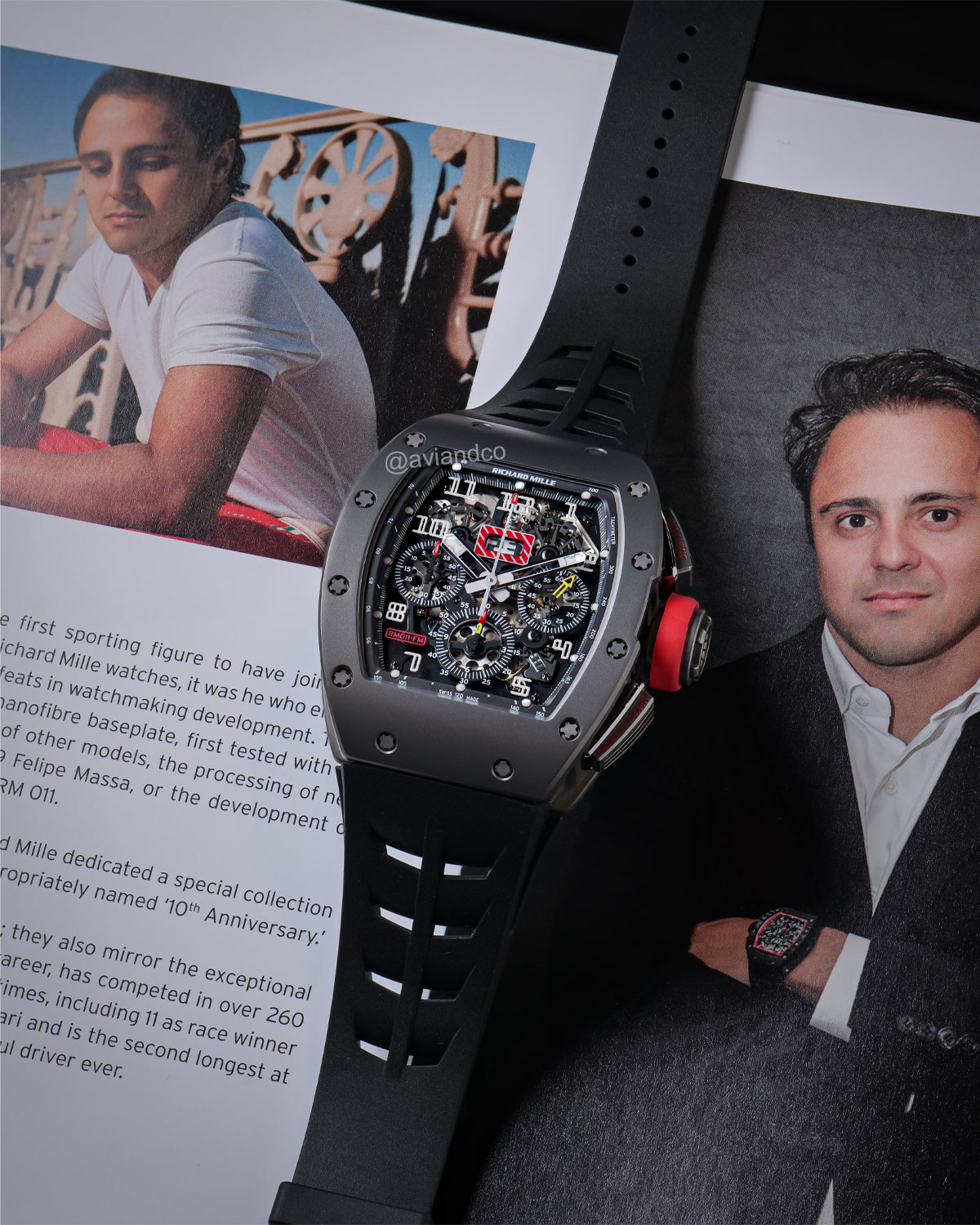 Titanium Case and Openworked Dial Richard Mille Timepiece with Black Rubber Strap Displayed on a C-Ring with a Black Background.