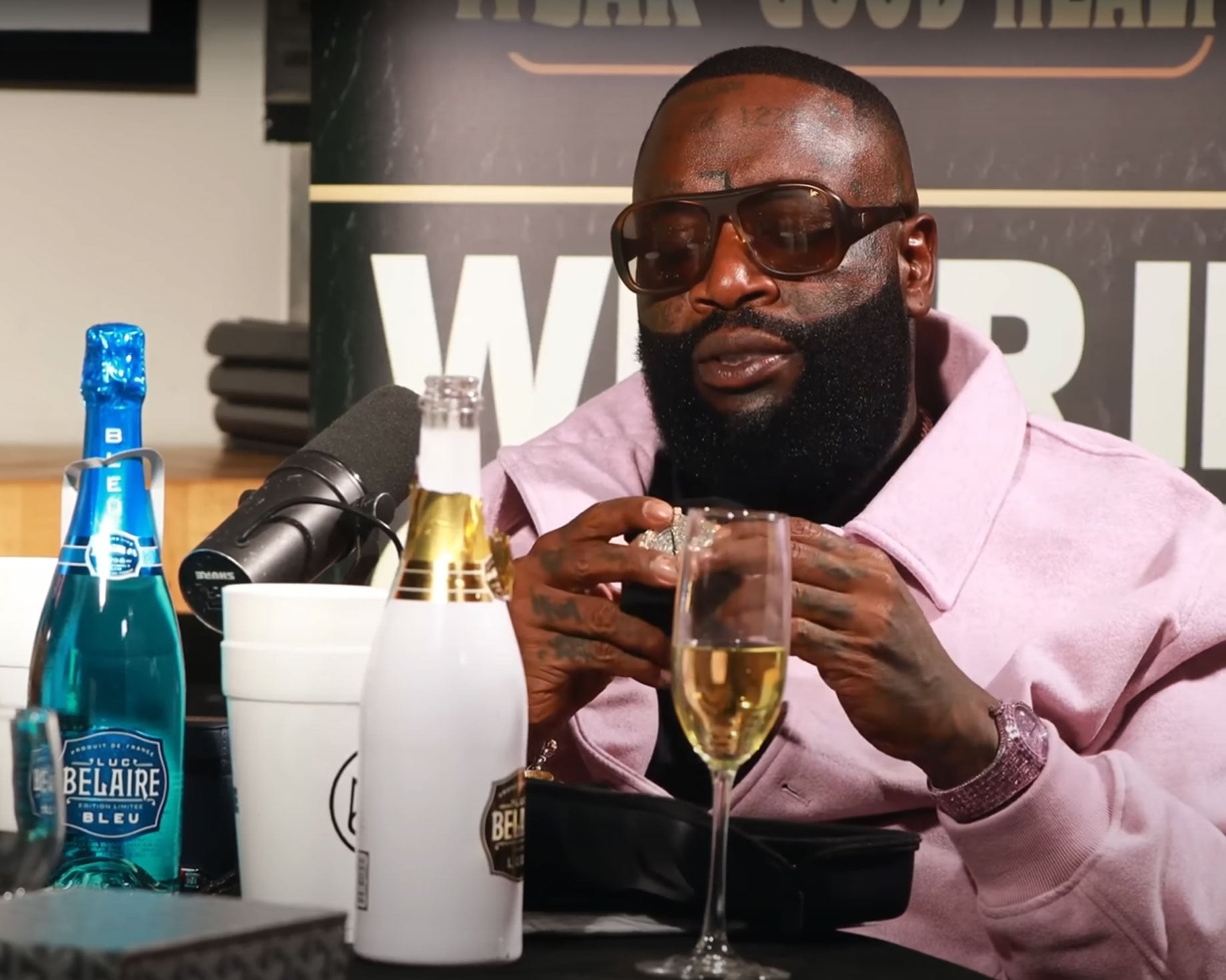 Rick Ross wears the Pink HUE watch while examining the 18K Rose Gold Frosted watch